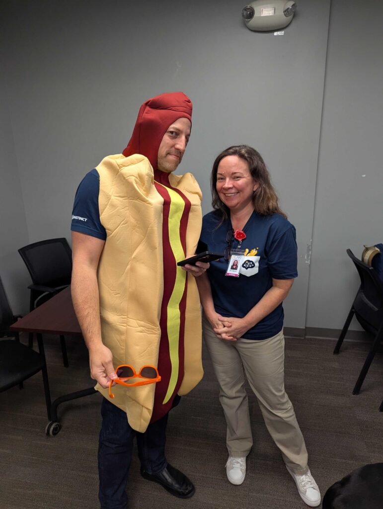 Dr. Caleb Frankel (on the left with a hot dog costume) poses for a photo with Dr. Peggy Sayer